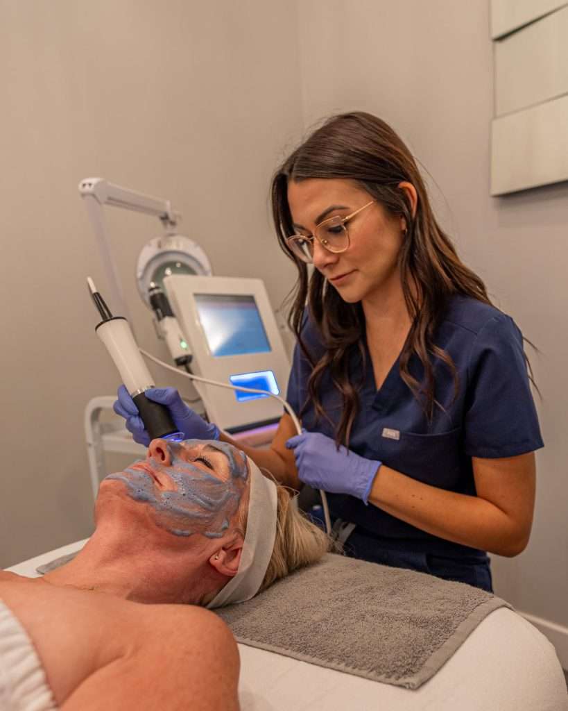 Esthetician performing a facial treatment at Ciao Bella