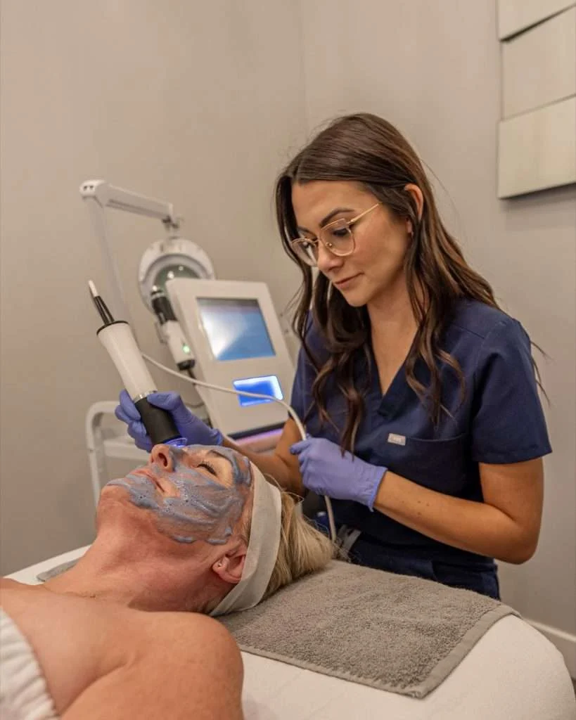 Esthetician performing an OxyGeneo facial with the Geneo machine